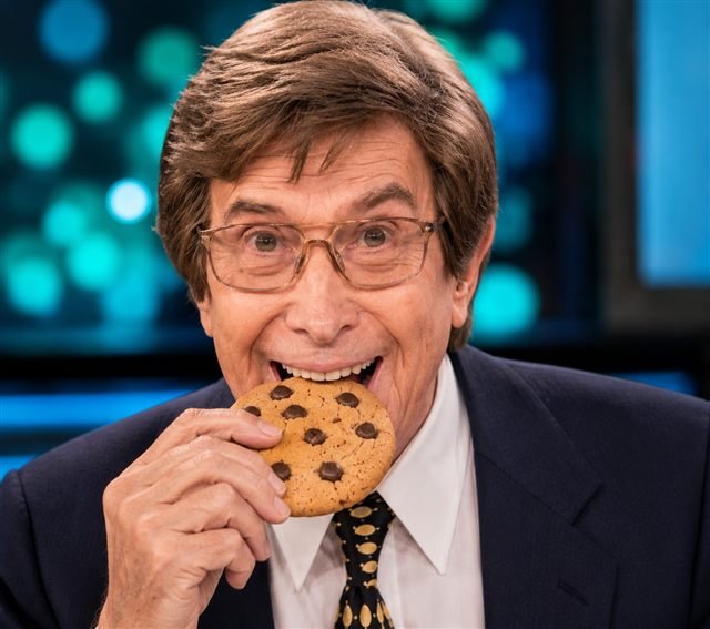 Silvio Soldán, con la peluca puesta, mordiendo una cookie